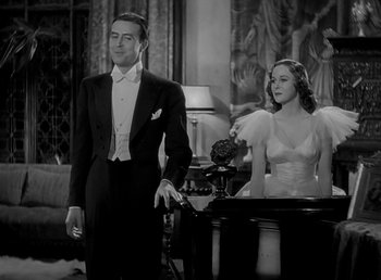 Movie still from “Beau Geste” (1939), directed by William A. Wellman – A man and a woman standing next to each other in a room; Medium shot, Low angle