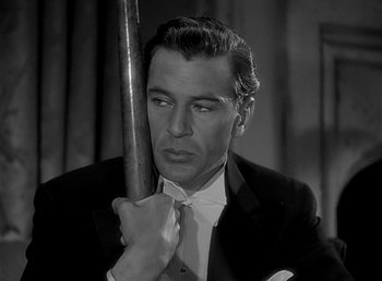 Movie still from “Beau Geste” (1939), directed by William A. Wellman – A black and white photo of a man holding a baseball bat; Close Up shot, Over the shoulder angle