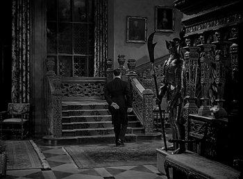 Movie still from “Beau Geste” (1939), directed by William A. Wellman – A black and white photo of a man walking up a staircase; Wide shot, High angle