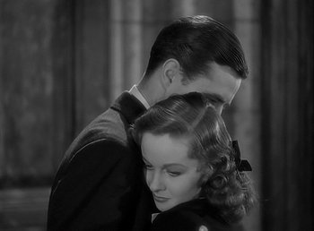 Movie still from “Beau Geste” (1939), directed by William A. Wellman – A man and a woman embracing each other in a black and white photo; Close Up shot, High angle