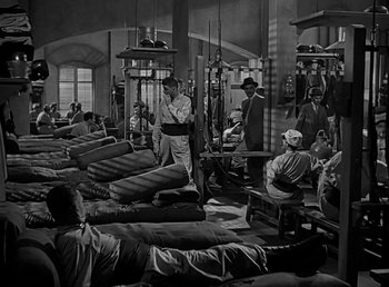 Movie still from “Beau Geste” (1939), directed by William A. Wellman – A black and white photo of men working in a factory; Wide shot, High angle