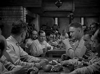 Movie still from “Beau Geste” (1939), directed by William A. Wellman – A black and white photo of men sitting at a table; Medium shot, High angle