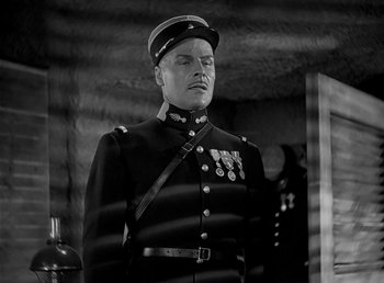 Movie still from “Beau Geste” (1939), directed by William A. Wellman – An old photo of a man in a military uniform; Medium shot, Low angle
