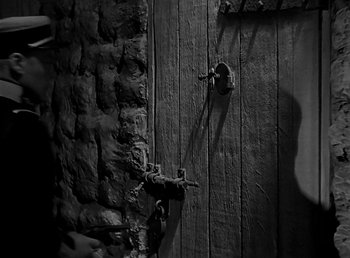 Movie still from “Beau Geste” (1939), directed by William A. Wellman – A black - and - white photo of a wooden door; Extreme Close Up shot, High angle
