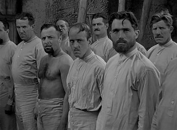 Movie still from “Beau Geste” (1939), directed by William A. Wellman – Black and white photograph of a group of men; Medium shot, Low angle