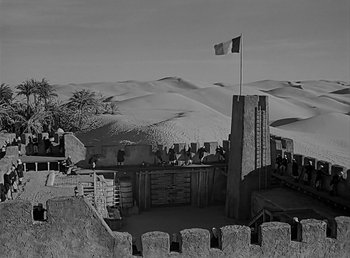 Movie still from “Beau Geste” (1939), directed by William A. Wellman – A black - and - white photo of a castle in the middle of the desert; Extreme Wide shot, High angle