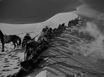 Movie still from “Beau Geste” (1939), directed by William A. Wellman – A black and white photo of a group of men on a hill; Wide shot, High angle