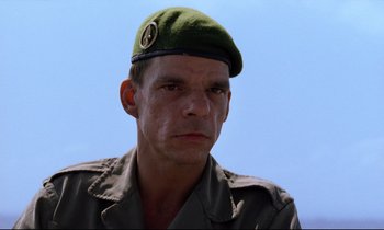 Movie still from “Beau Travail” (1999), directed by Claire Denis – A man wearing a green beret and a green jacket; Close Up shot, Low angle