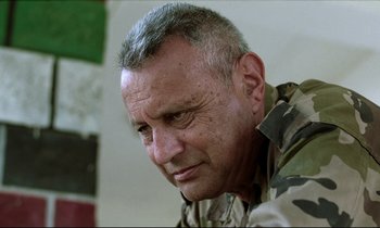 Movie still from “Beau Travail” (1999), directed by Claire Denis – A person wearing a military uniform; Close Up shot, Low angle