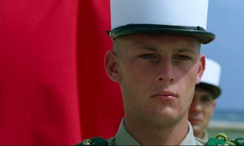 Movie still from “Beau Travail” (1999), directed by Claire Denis – A man in a military uniform is looking at the camera; Close Up shot, Low angle
