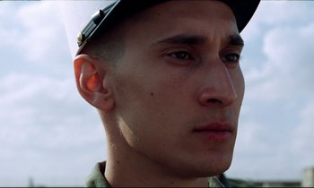 Movie still from “Beau Travail” (1999), directed by Claire Denis – A person wearing a hat; Close Up shot, Low angle