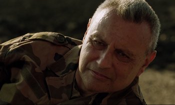 Movie still from “Beau Travail” (1999), directed by Claire Denis – A person wearing a military uniform; Close Up shot, Low angle