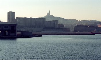 Movie still from “Beau Travail” (1999), directed by Claire Denis – A large body of water near a large city; Extreme Wide shot, High angle