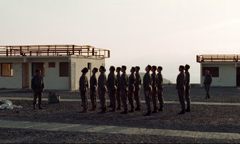 Movie still from “Beau Travail” (1999), directed by Claire Denis – A group of men standing next to each other on top of a hill; Extreme Wide shot, Low angle