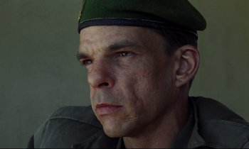 Movie still from “Beau Travail” (1999), directed by Claire Denis – A person wearing a hat; Close Up shot, Low angle