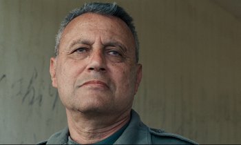 Movie still from “Beau Travail” (1999), directed by Claire Denis – A person wearing a military uniform; Close Up shot, Low angle