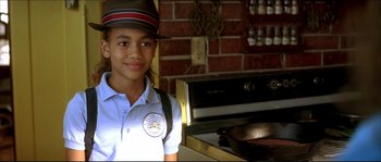 Movie still from “Beauty Shop” (2005), directed by Bille Woodruff – A young girl in a hat is standing in front of an oven; Close Up shot, High angle
