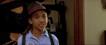 Movie still from “Beauty Shop” (2005), directed by Bille Woodruff – A young man wearing a hat and suspenders; Close Up shot, High angle