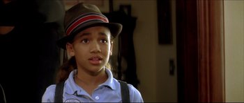 Movie still from “Beauty Shop” (2005), directed by Bille Woodruff – A young boy wearing a brown hat and suspenders looks at the camera; Close Up shot, High angle