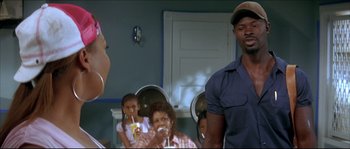 Movie still from “Beauty Shop” (2005), directed by Bille Woodruff – A man and a woman in front of a bathroom mirror; Medium shot, Over the shoulder angle