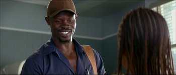 Movie still from “Beauty Shop” (2005), directed by Bille Woodruff – A man wearing a hat and smiling at a woman; Close Up shot, Low angle