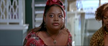 Movie still from “Beauty Shop” (2005), directed by Bille Woodruff – A person wearing a dress and a bow; Close Up shot, Over the shoulder angle
