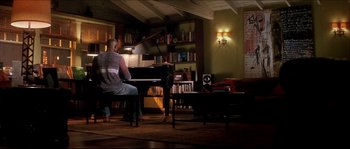 Movie still from “Beauty Shop” (2005), directed by Bille Woodruff – A woman sitting at a piano in a living room; Wide shot, Low angle