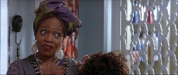 Movie still from “Beauty Shop” (2005), directed by Bille Woodruff – A woman with a purple head wrap on her head; Close Up shot, Over the shoulder angle