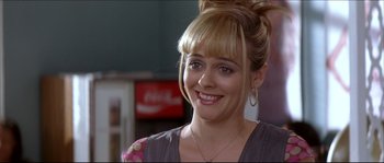 Movie still from “Beauty Shop” (2005), directed by Bille Woodruff – A person wearing a dress smiling; Close Up shot, Over the shoulder angle