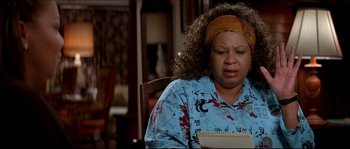 Movie still from “Beauty Shop” (2005), directed by Bille Woodruff – A woman sitting at a table with a notepad in front of her; Close Up shot, High angle