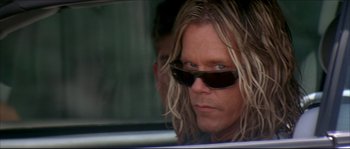 Movie still from “Beauty Shop” (2005), directed by Bille Woodruff – A man with long blonde hair wearing sunglasses looking out of a car window; Close Up shot, Low angle