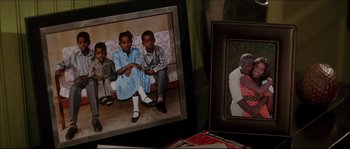 Movie still from “Beauty Shop” (2005), directed by Bille Woodruff – A couple of pictures of a man and a woman and a child; Extreme Close Up shot, High angle