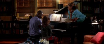 Movie still from “Beauty Shop” (2005), directed by Bille Woodruff – A man and two women sitting at a grand piano; Medium shot, High angle
