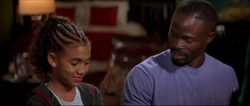 Movie still from “Beauty Shop” (2005), directed by Bille Woodruff – A man and a woman sitting next to each other in a living room; Close Up shot, Over the shoulder angle