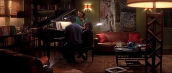 Movie still from “Beauty Shop” (2005), directed by Bille Woodruff – Two people sitting in front of a piano in a living room; Wide shot, High angle