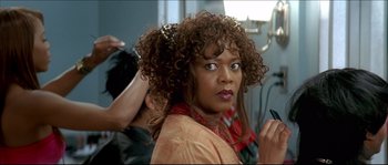 Movie still from “Beauty Shop” (2005), directed by Bille Woodruff – A person with curly hair in a room; Close Up shot, Over the shoulder angle