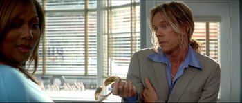 Movie still from “Beauty Shop” (2005), directed by Bille Woodruff – A man in a suit holding a pair of sunglasses; Close Up shot, Over the shoulder angle