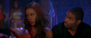 Movie still from “Beauty Shop” (2005), directed by Bille Woodruff – A woman sitting next to a man in a room; Close Up shot, Over the shoulder angle
