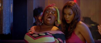 Movie still from “Beauty Shop” (2005), directed by Bille Woodruff – A woman with pink and yellow hair and a woman with brown hair; Medium shot, Over the shoulder angle