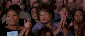 Movie still from “Beauty Shop” (2005), directed by Bille Woodruff – An older woman is smiling and clapping in a crowd; Close Up shot, Low angle