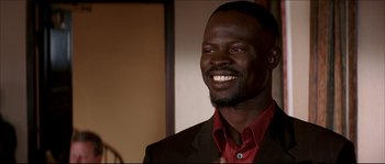 Movie still from “Beauty Shop” (2005), directed by Bille Woodruff – A man in a red shirt and a black suit; Close Up shot, High angle