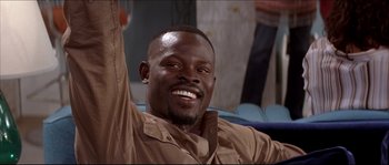 Movie still from “Beauty Shop” (2005), directed by Bille Woodruff – A man smiling and raising his hand in the air; Close Up shot, Low angle