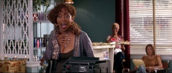 Movie still from “Beauty Shop” (2005), directed by Bille Woodruff – A woman standing in front of a tv; Medium shot, Low angle