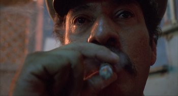 Movie still from “Before Night Falls” (2000), directed by Julian Schnabel – A person holding a cigarette in his mouth; Extreme Close Up shot, Low angle