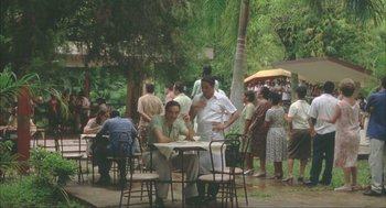 Movie still from “Before Night Falls” (2000), directed by Julian Schnabel – A group of people sitting at a table outside; Wide shot, High angle