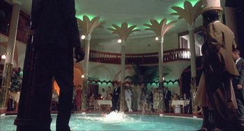 Movie still from “Before Night Falls” (2000), directed by Julian Schnabel – A group of people standing around a pool of water; Extreme Wide shot, Low angle