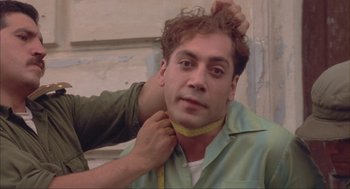 Movie still from “Before Night Falls” (2000), directed by Julian Schnabel – A man with a measuring tape around his neck; Close Up shot, Low angle
