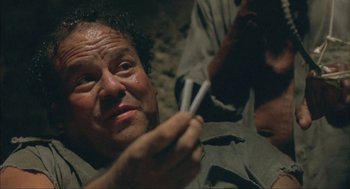 Movie still from “Before Night Falls” (2000), directed by Julian Schnabel – An older man is holding a pair of cigarette lighters in his hand; Close Up shot, High angle