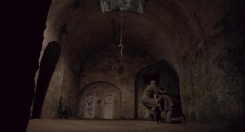 Movie still from “Before Night Falls” (2000), directed by Julian Schnabel – Two men are in an old building with a rope hanging from the ceiling; Wide shot, Low angle
