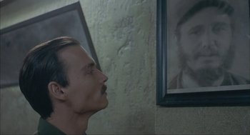 Movie still from “Before Night Falls” (2000), directed by Julian Schnabel – A man standing in front of a picture of a man; Close Up shot, Over the shoulder angle